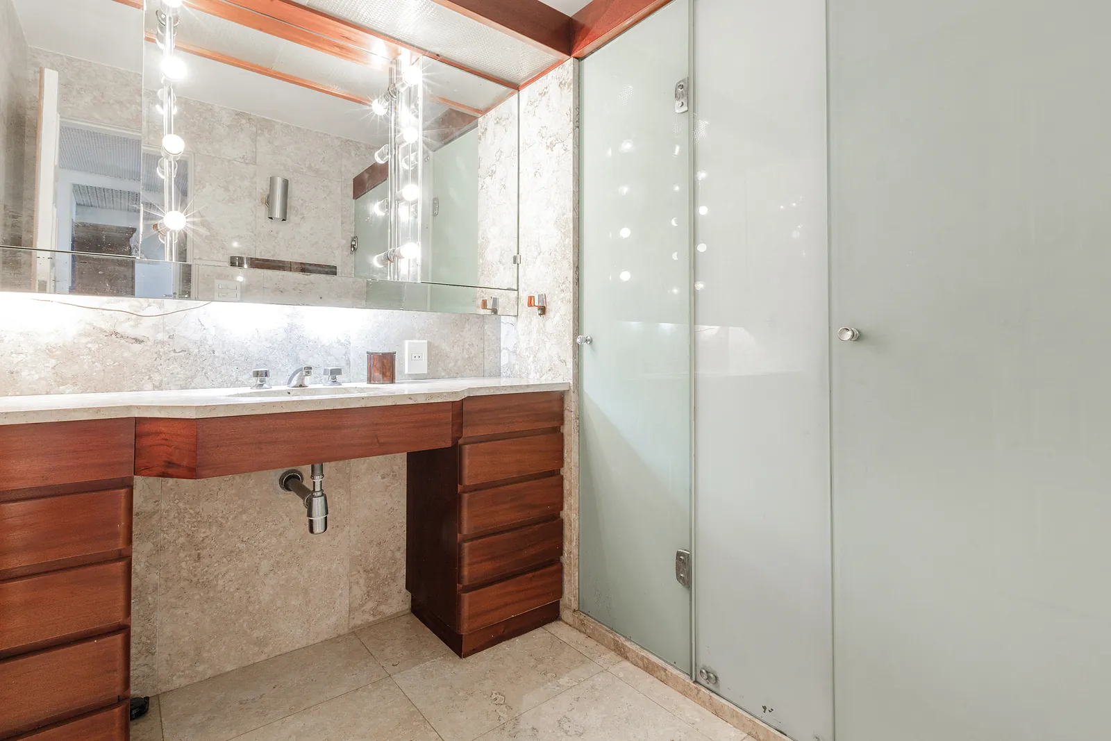 A bathroom with a double vanity and a wide mirror