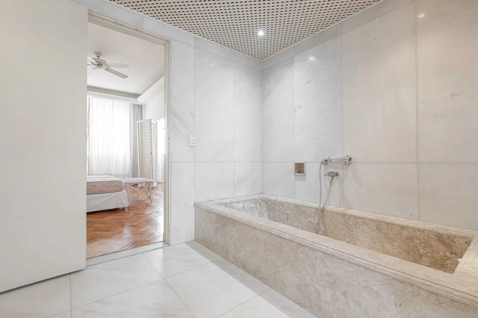 A marble bathroom with a sunken tub