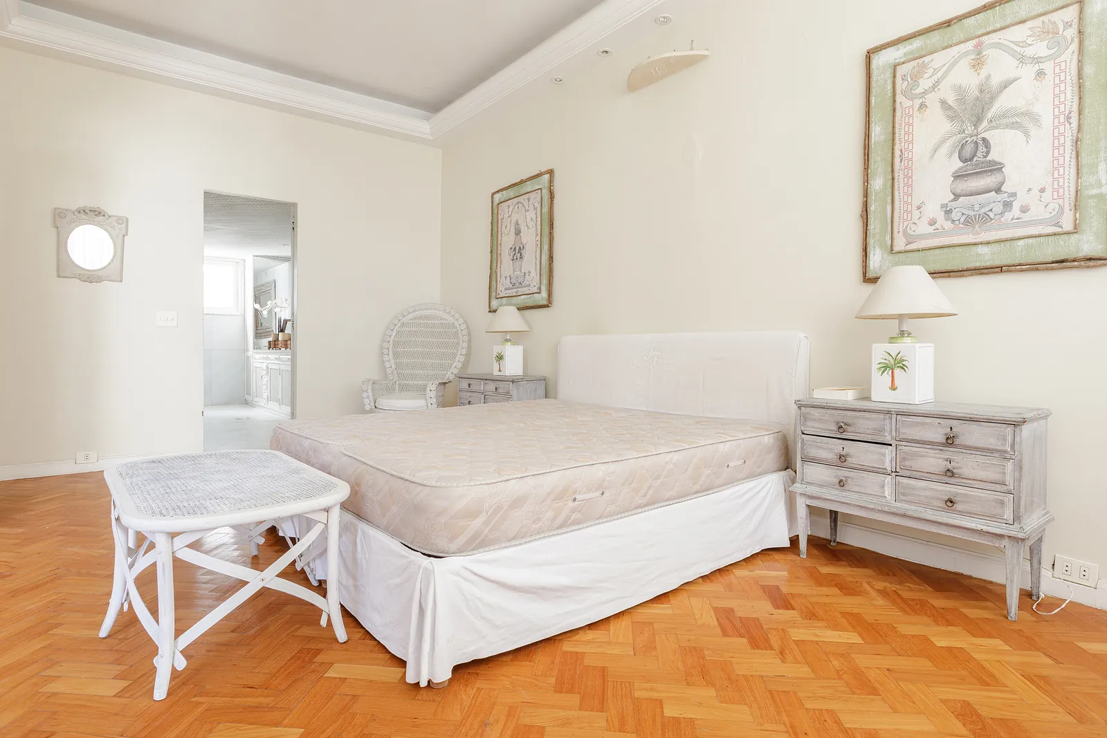 The primary bedroom, a bed, dressers and framed art