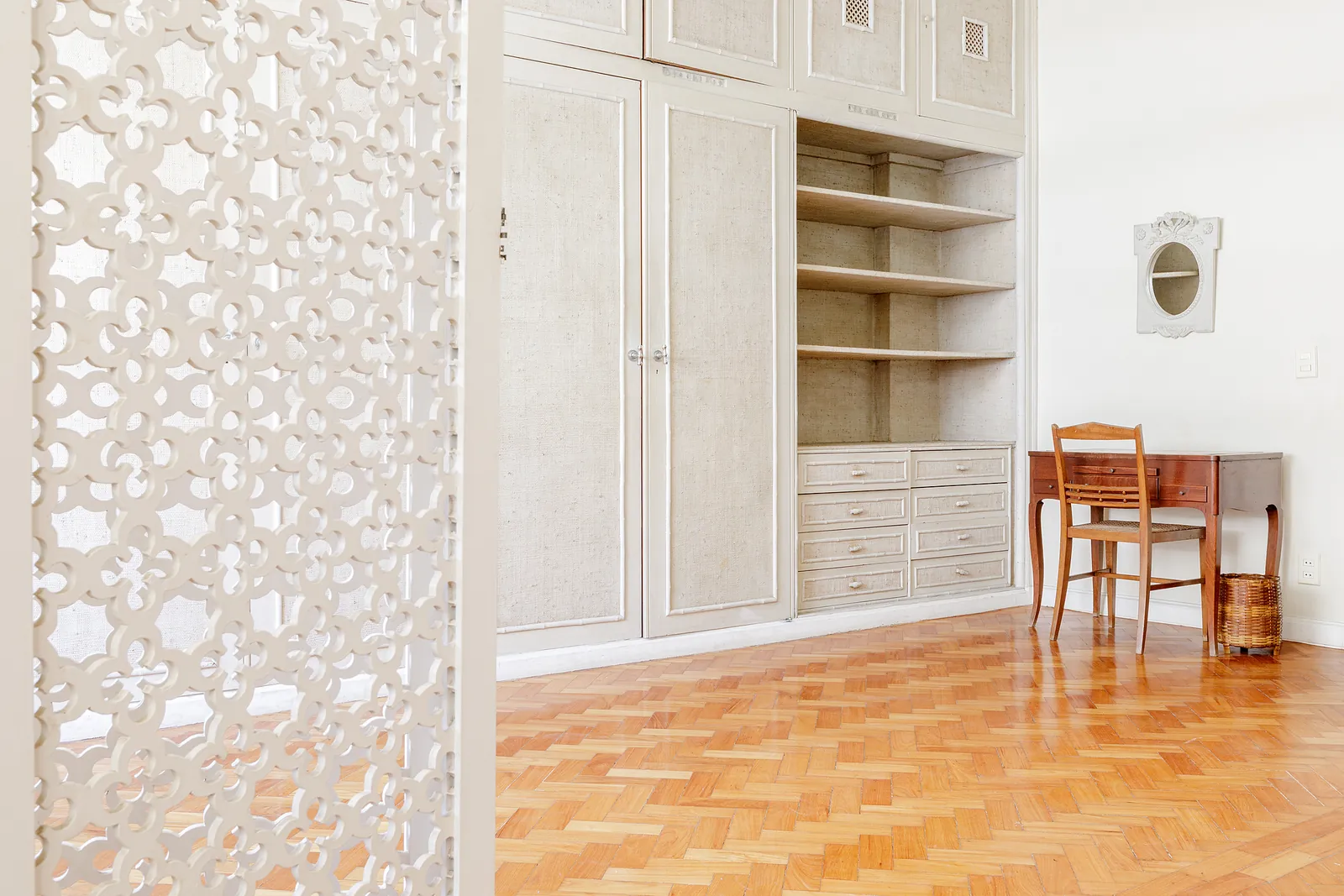 A bedroom with a pierced screen and open shelving