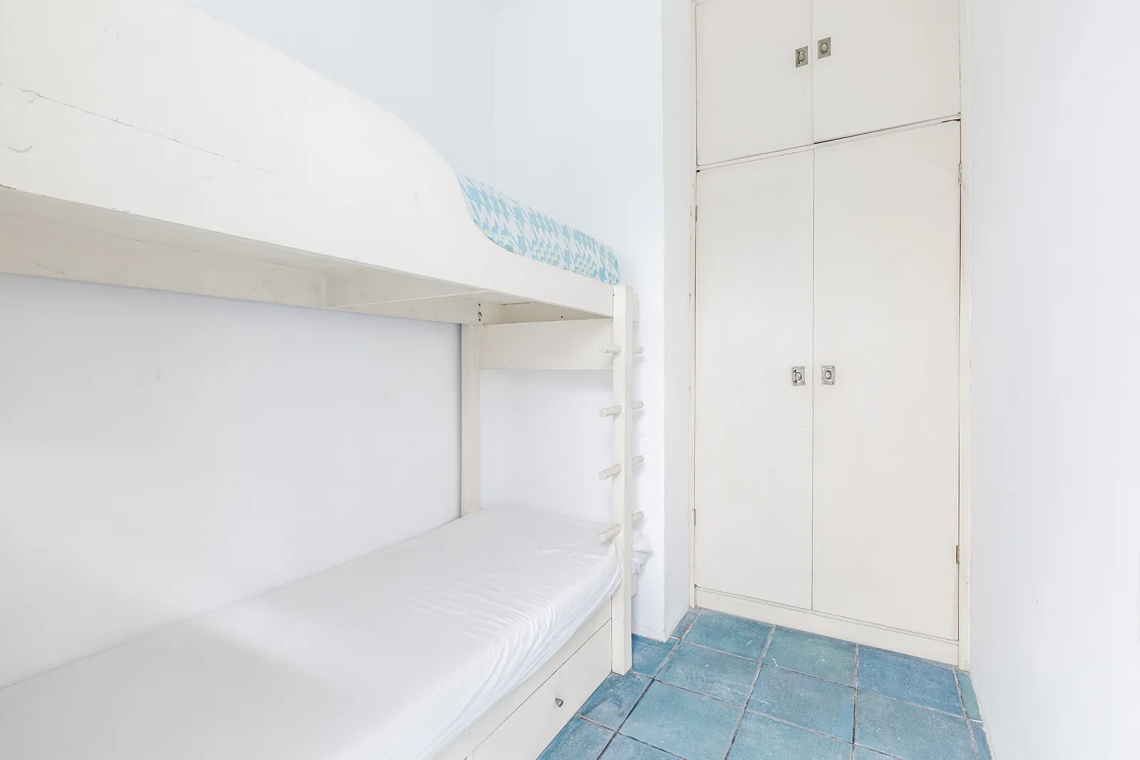 A simple bedroom in white with fitted storage