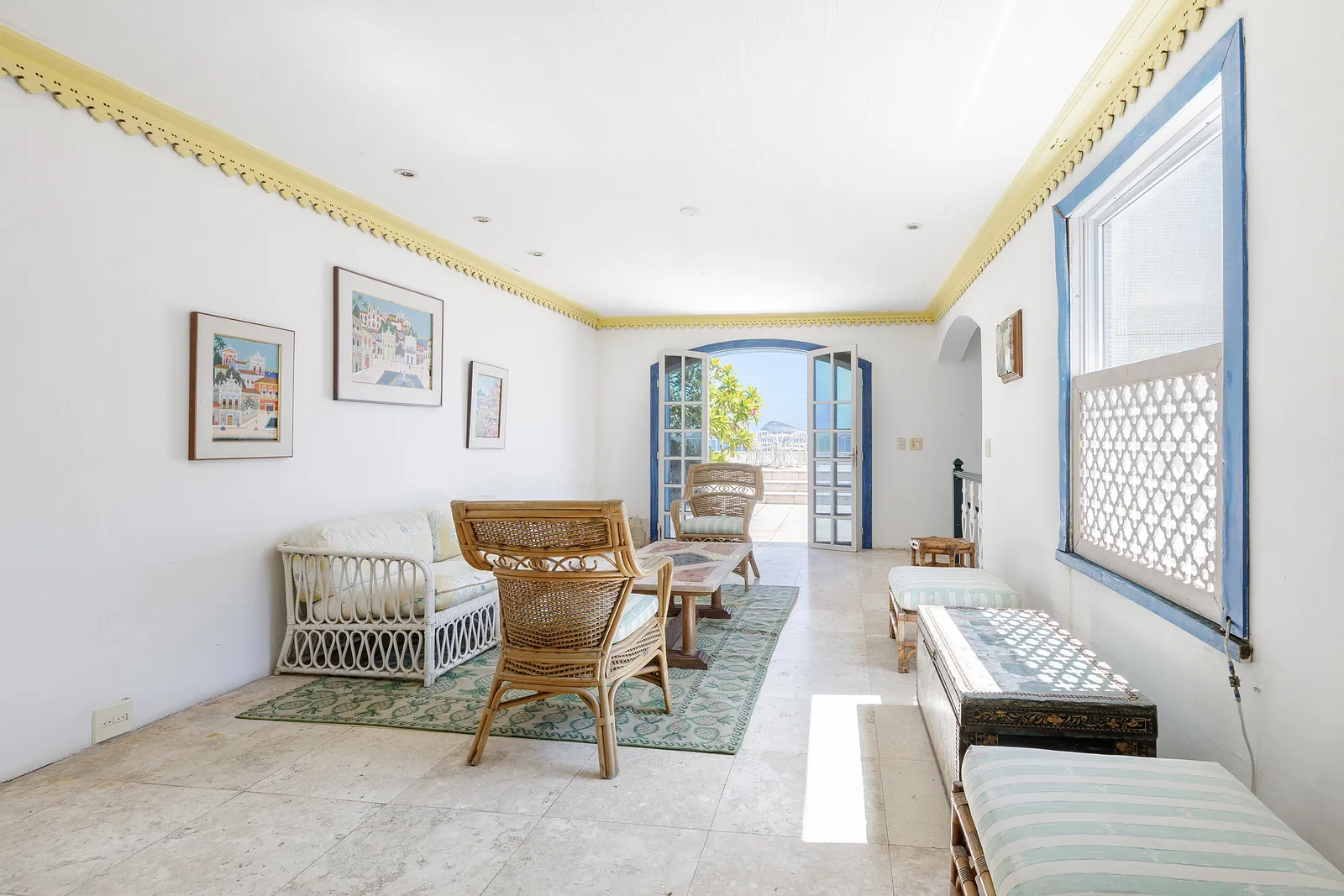 A sitting room with artwork and a window to the terrace