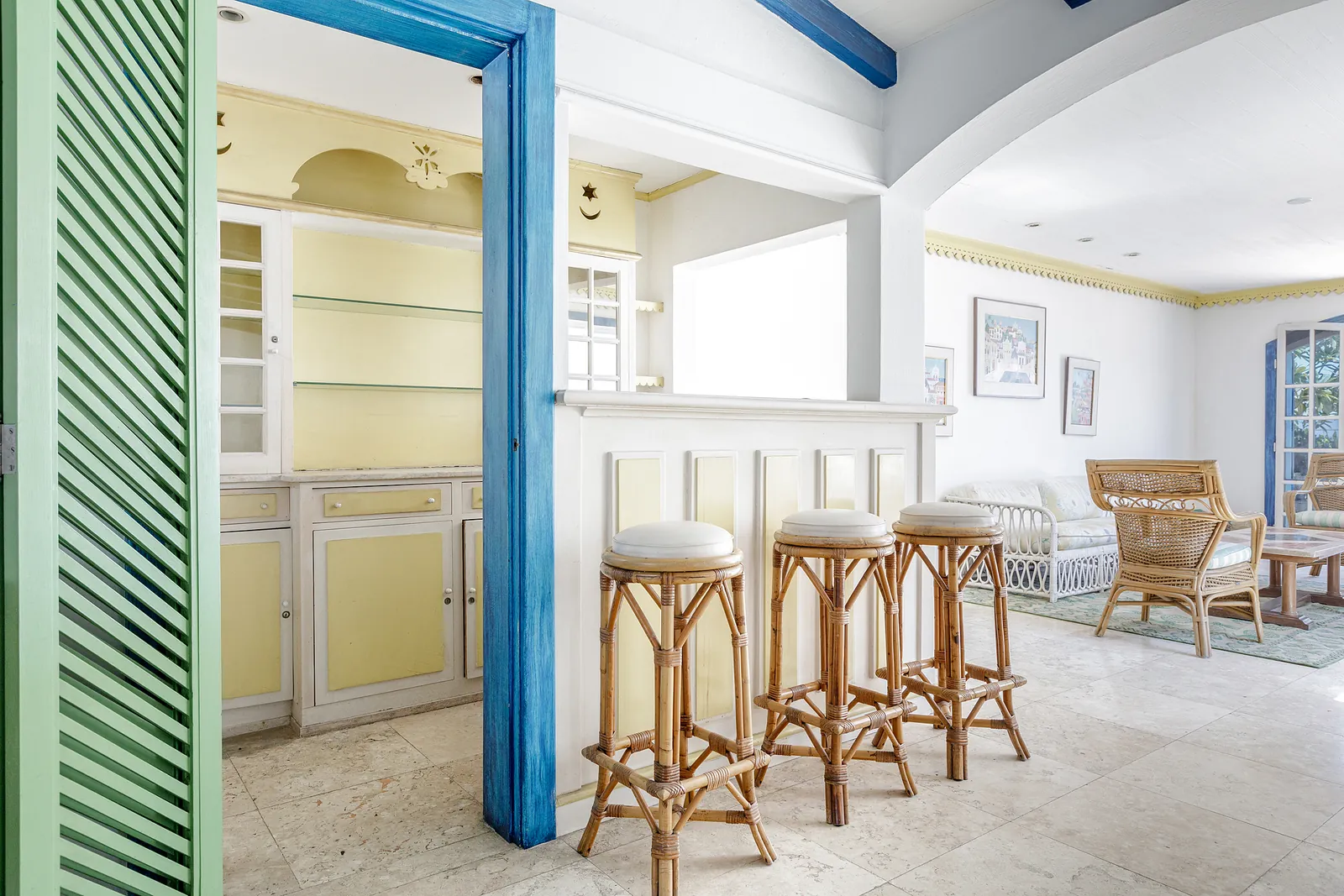 A bar area with stools and louvred doors