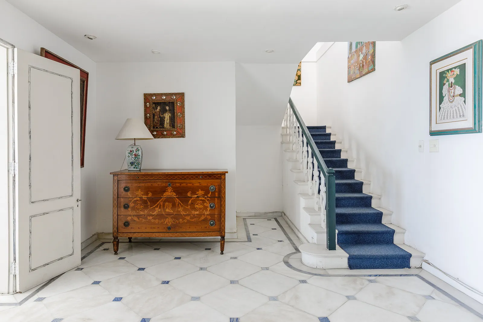 The interior staircase, a blue runner and an antique chest