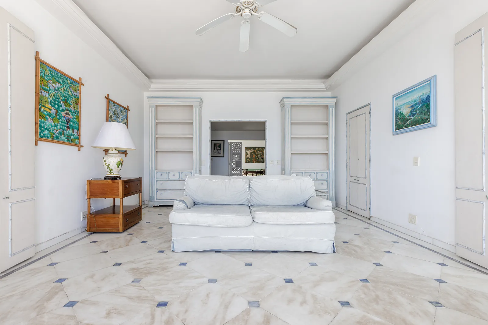 A living room in white, sofas, artwork and panelling