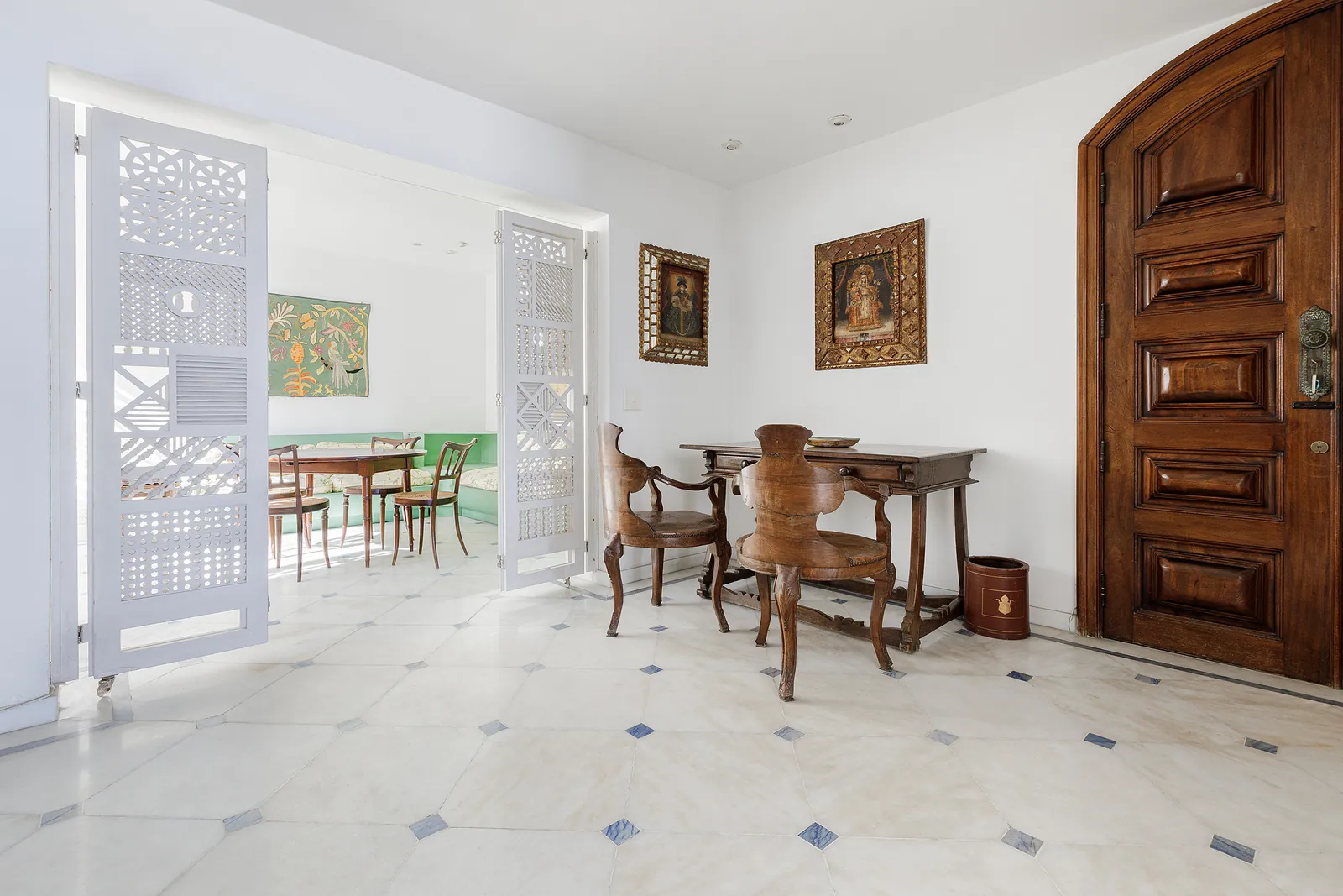 The entrance, a carved wooden door and the dining room beyond