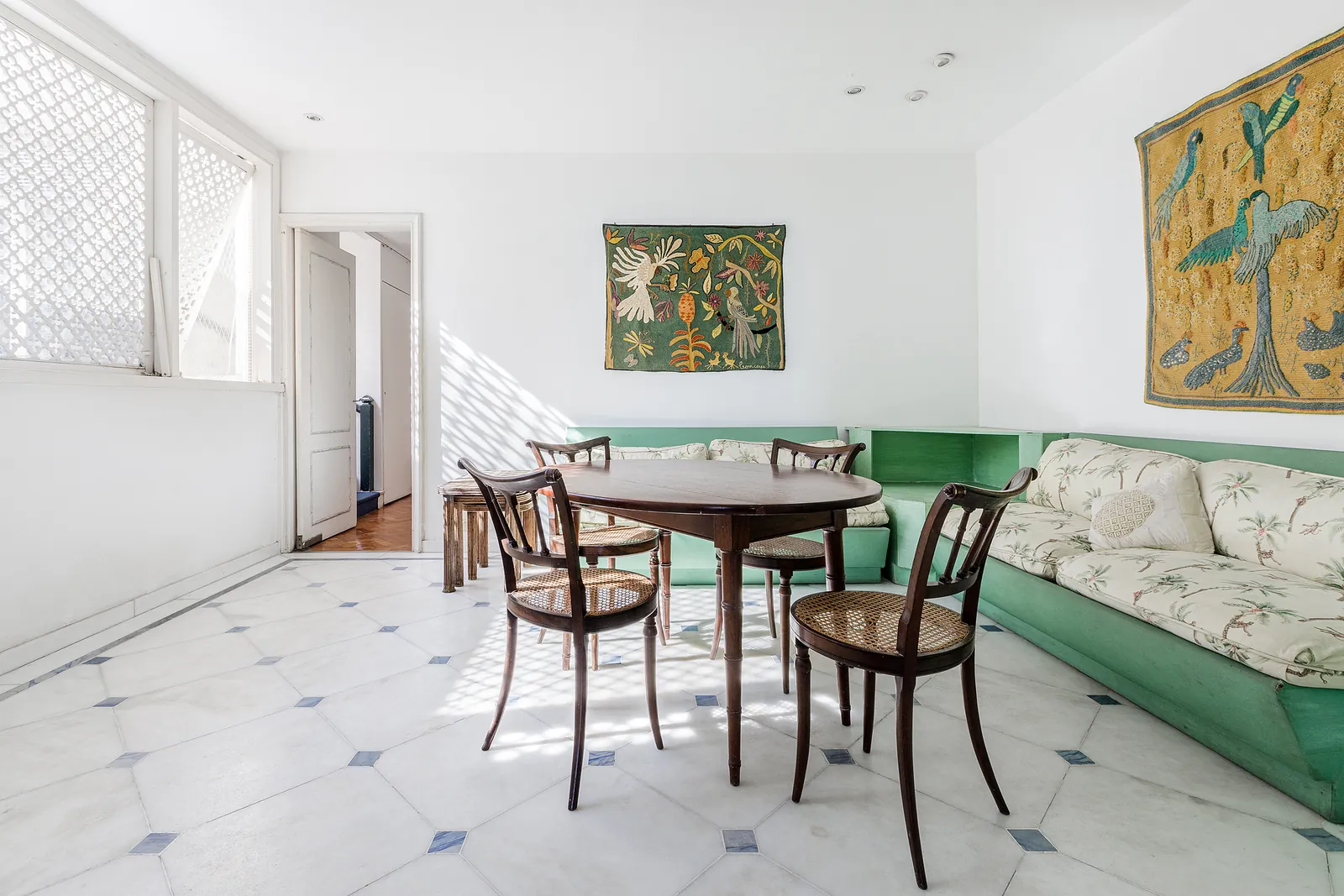 A dining room with a round table and a green sofa