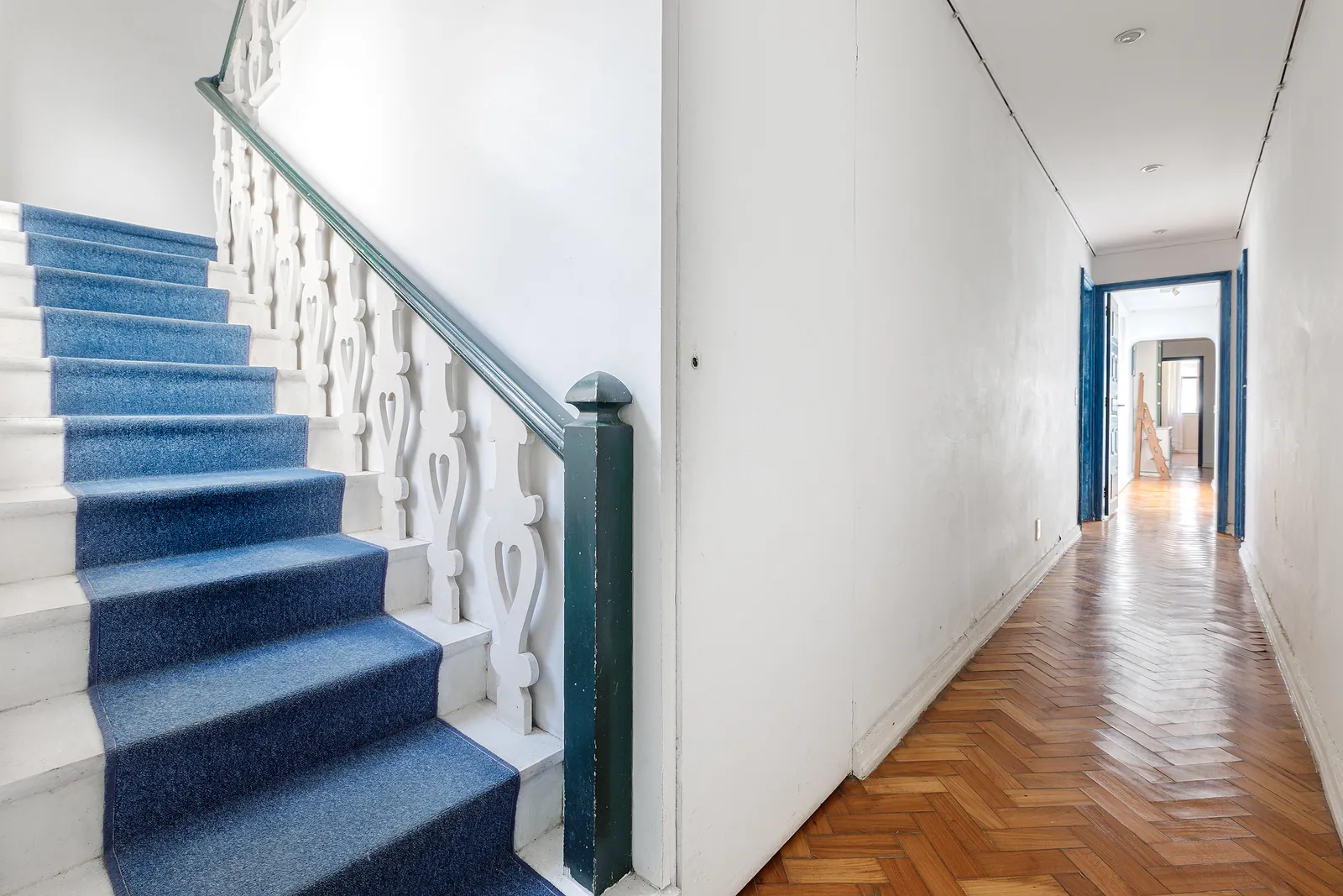 The duplex staircase, blue-carpeted, and the corridor beyond