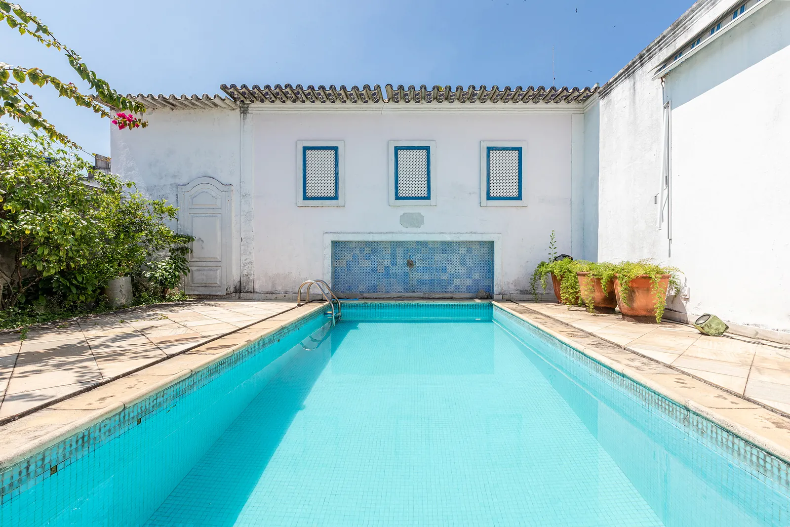 The pool seen lengthwise, a tiled wall running down one side