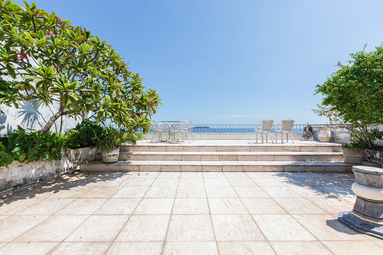 An open rooftop terrace with loungers facing the ocean